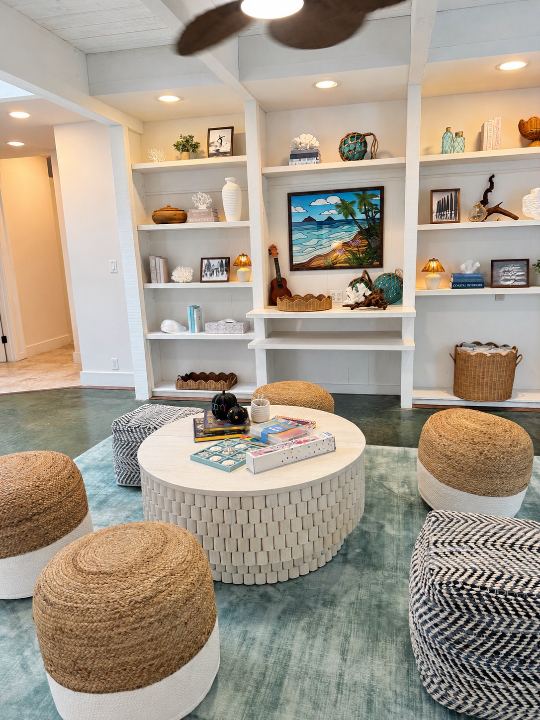 Lounge with curated shelves, ocean art and textured stools