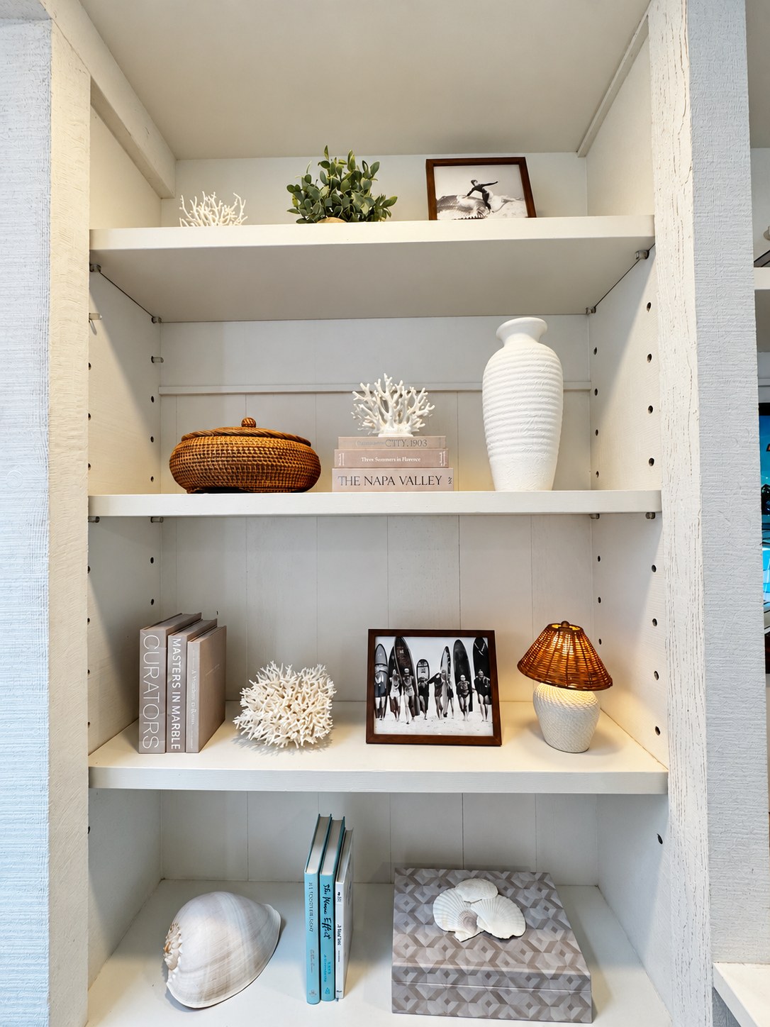 Carefully styled shelves with ceramics, framed photos and natural textures